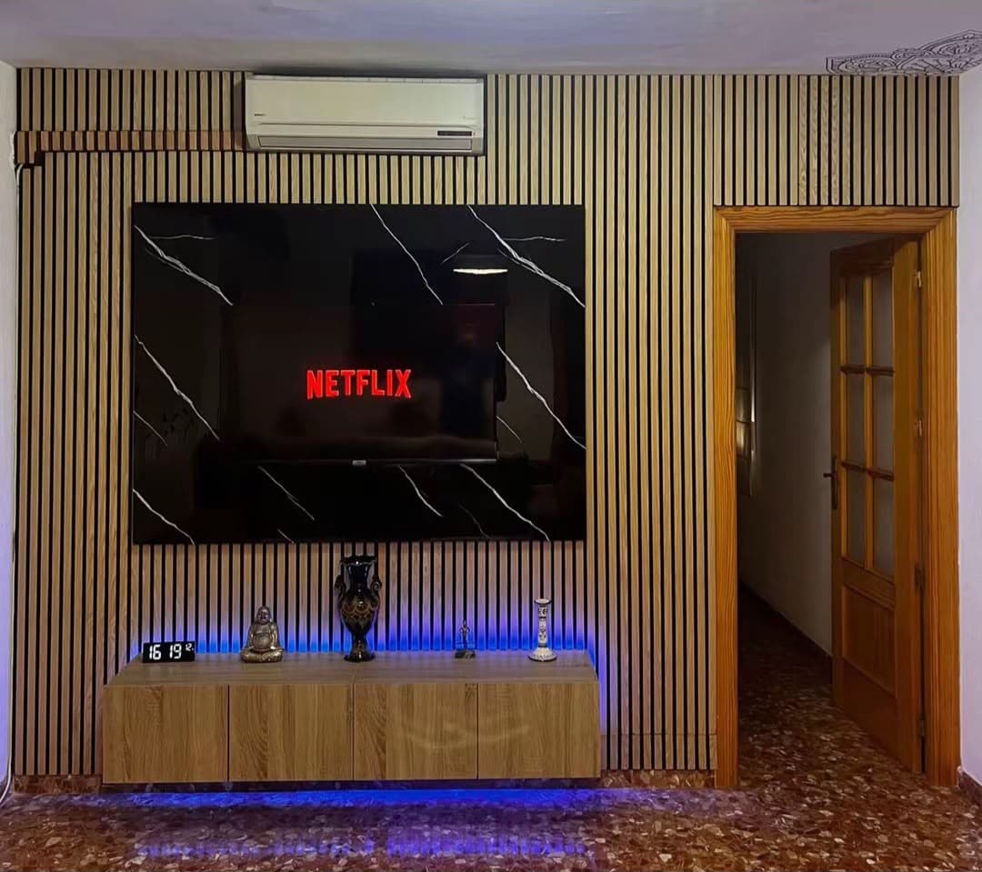 Después — Una pared entera de palillería de madera, con luz indirecta
