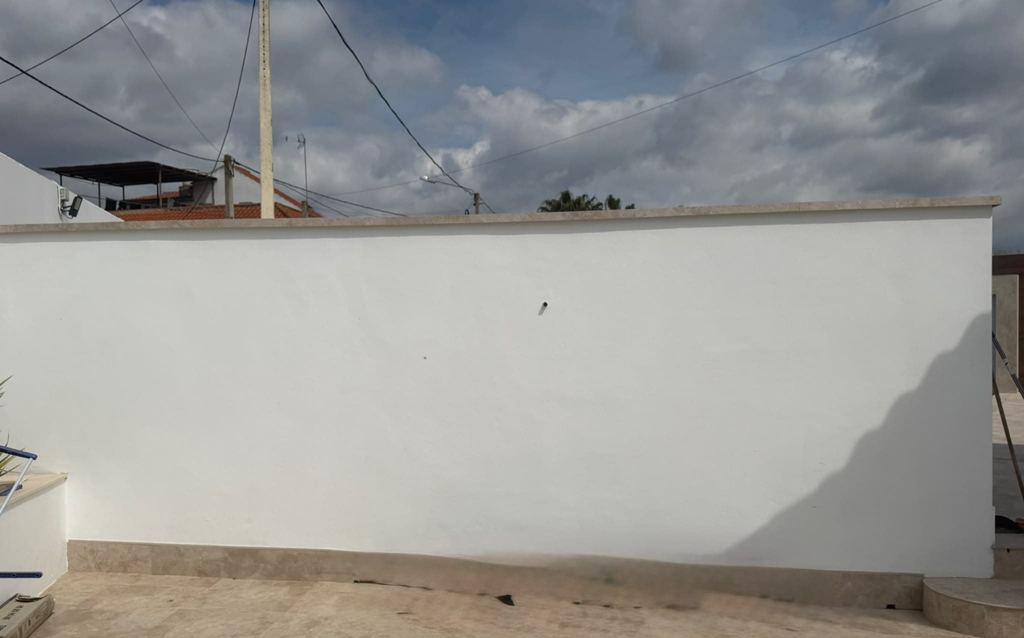 Antes — Una fachada de mármol y luz, montada sobre el muro que ya estaba