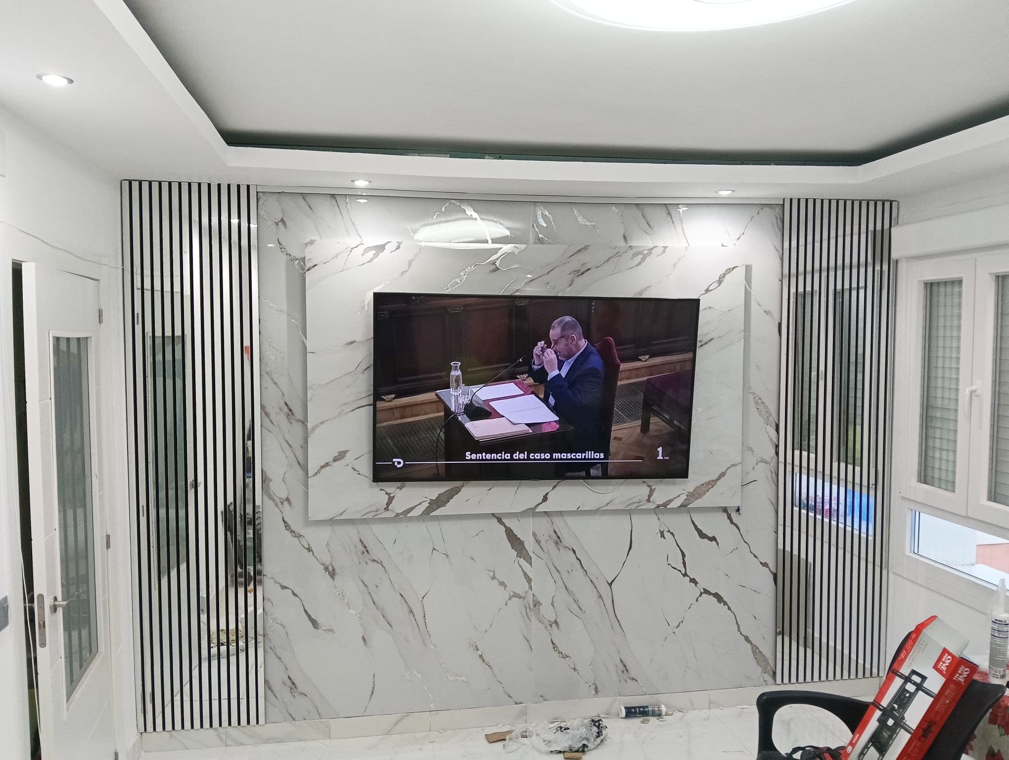 Después — Pared de televisión en mármol Calacatta, montada en una mañana